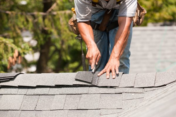 A Roofer Laying down Shingles - Residential roofing
